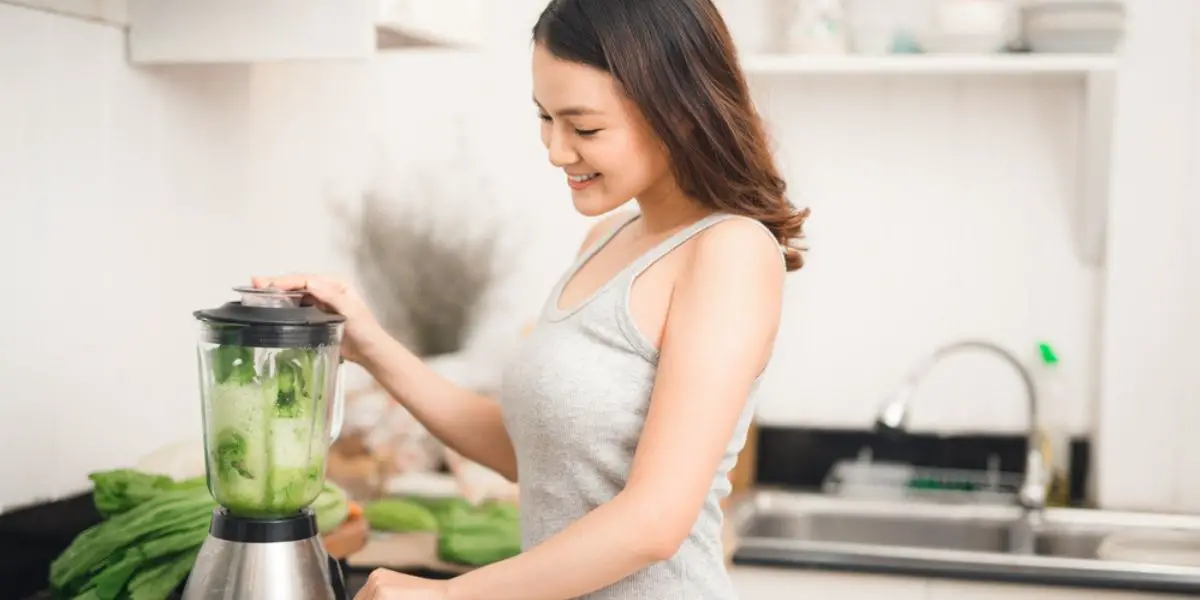 woman chopping vegetables in a blender